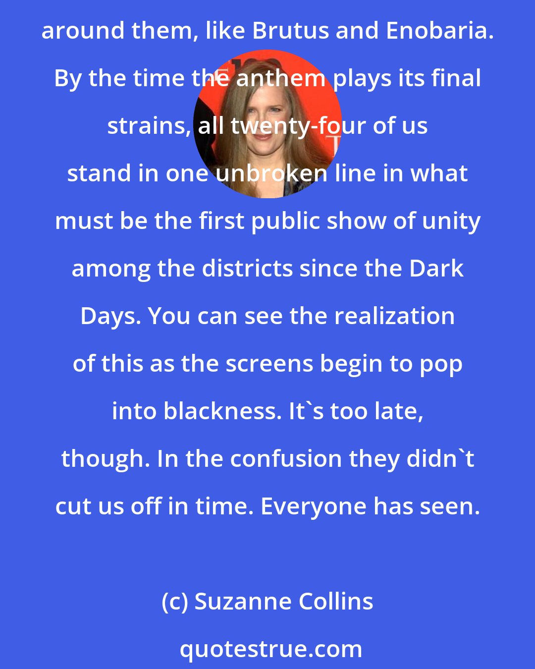 Suzanne Collins: And then it happens. Up and down the row, the victors begin to join hands. Some right away, like the morphlings, or Wiress and Beetee. Others unsure but caught up in the demands of those around them, like Brutus and Enobaria. By the time the anthem plays its final strains, all twenty-four of us stand in one unbroken line in what must be the first public show of unity among the districts since the Dark Days. You can see the realization of this as the screens begin to pop into blackness. It's too late, though. In the confusion they didn't cut us off in time. Everyone has seen.